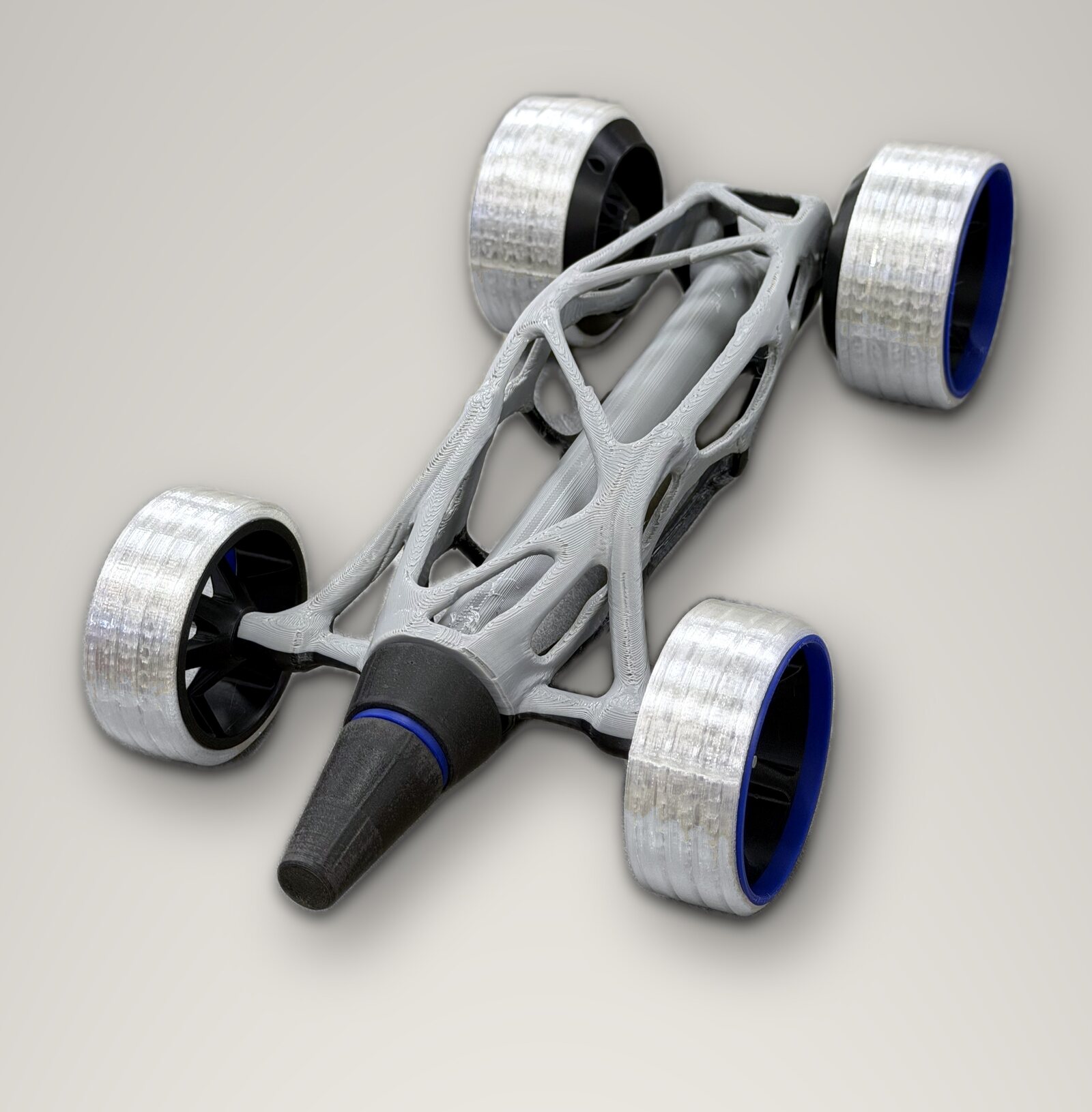 The finished car, black and gray printed lattice with clear tires, on a studio sweep